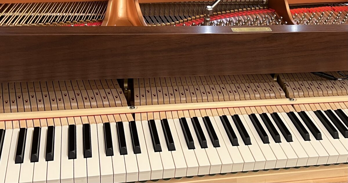 木製フレームのグランドピアノの鍵盤と内部構造