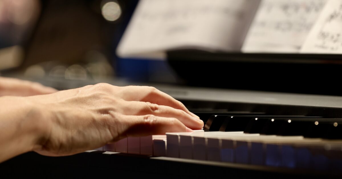 楽譜を見ながらピアノを演奏する手元のアップ