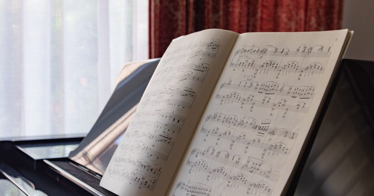 窓際に置かれたピアノの譜面台に開かれた楽譜