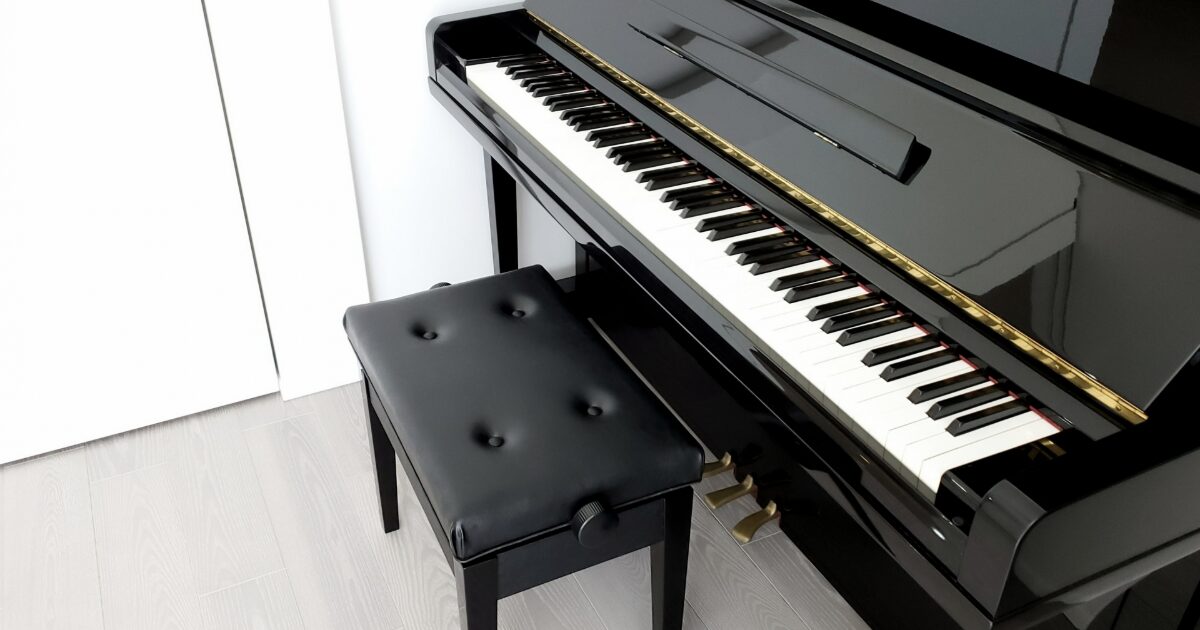 黒い椅子とアップライトピアノの鍵盤全体