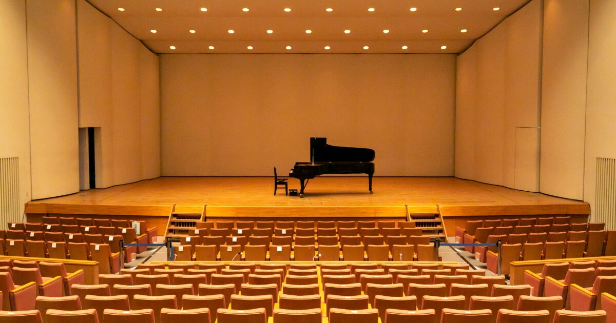 コンサートホールのステージ中央に置かれたグランドピアノ